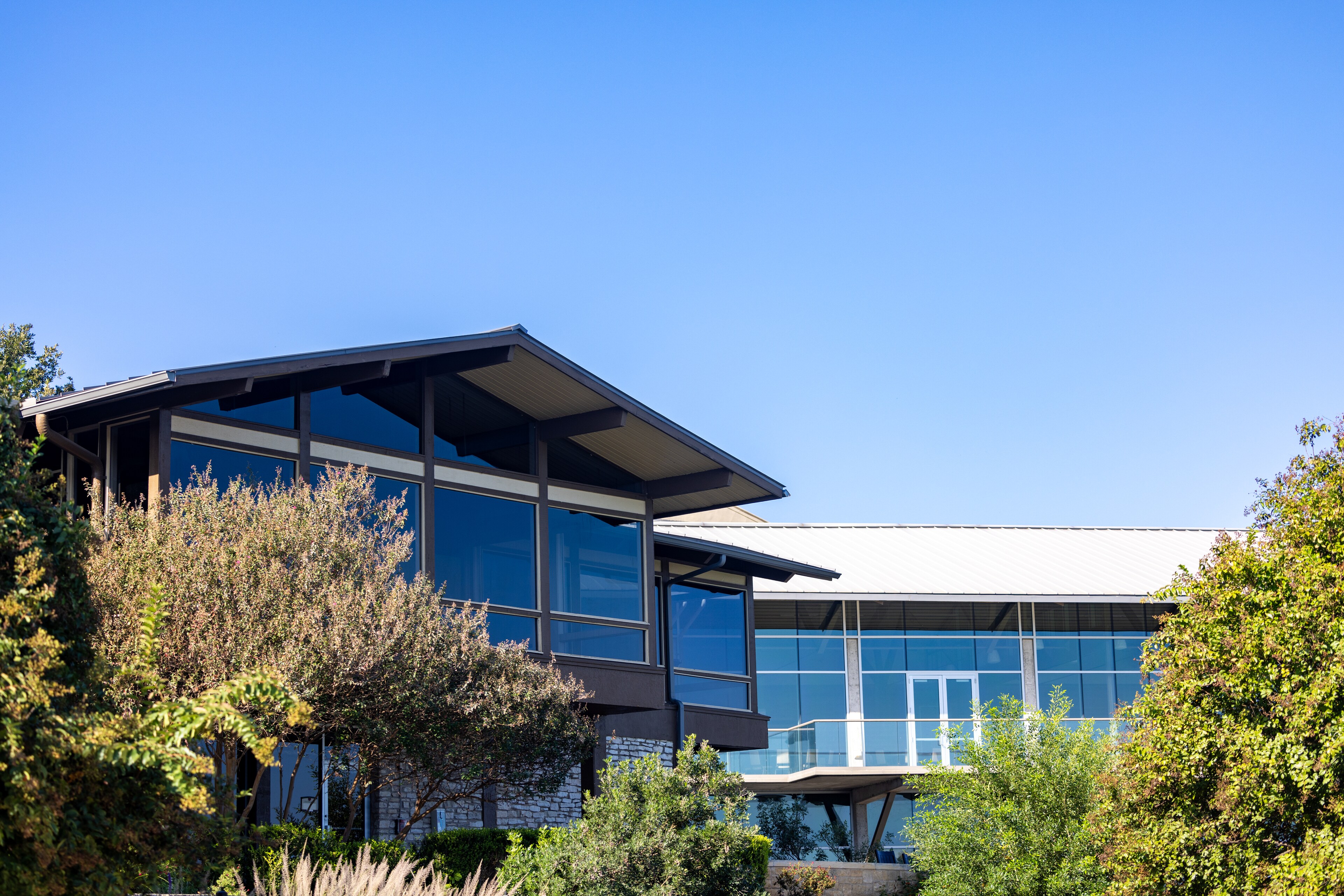 Modern glass building with angular roof surrounded by trees - Lakeway Resort & Spa, Texas