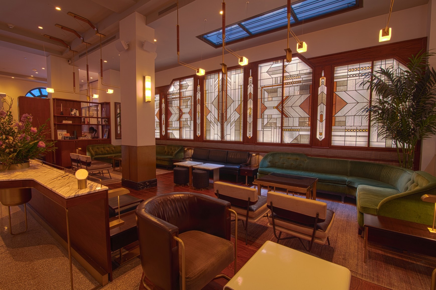 A lobby lounge with seating areas and stained glass windows