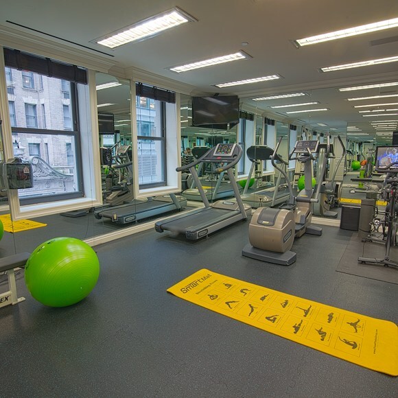 A well-equipped gym with exercise equipment and a large mirror.