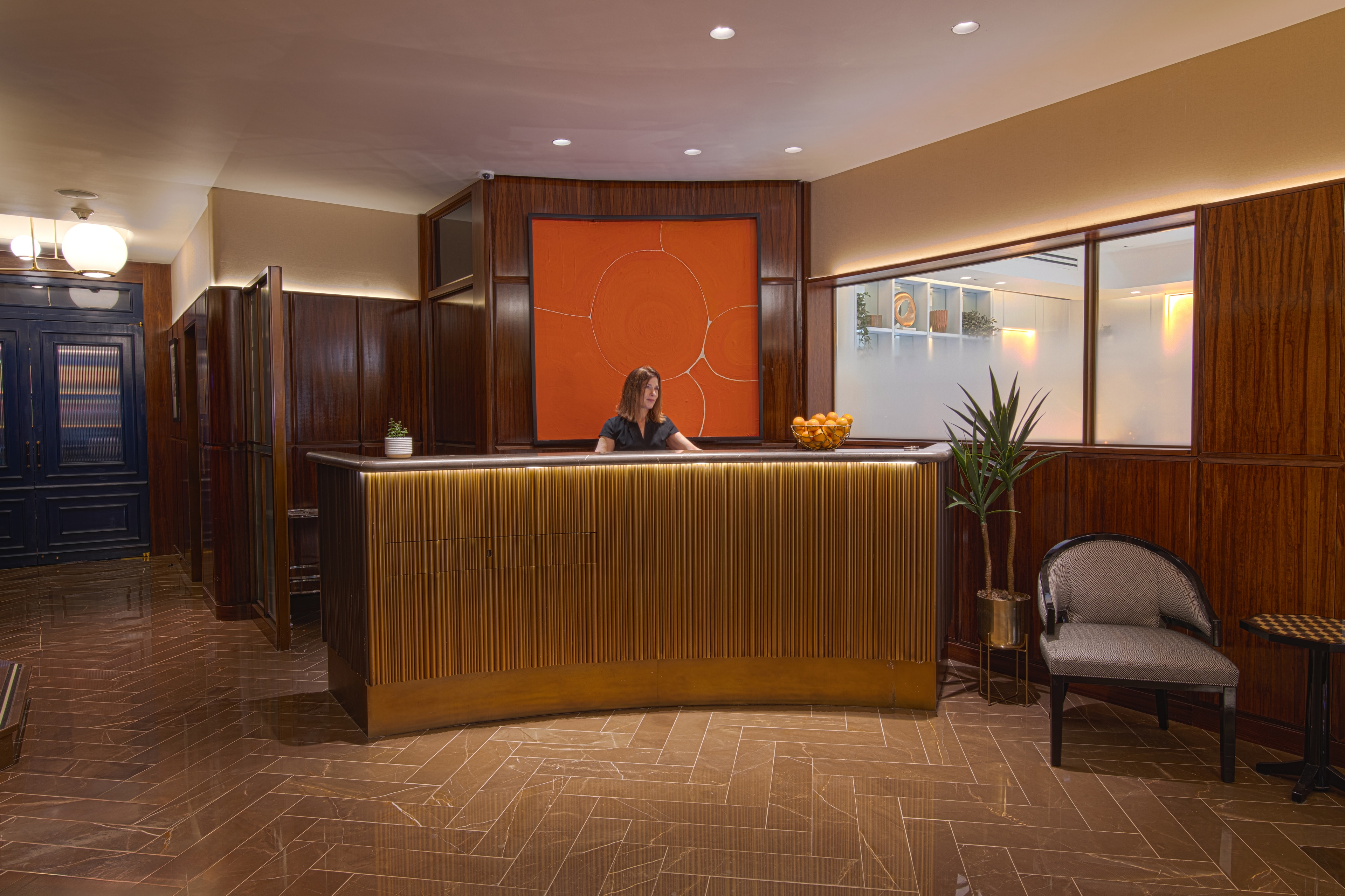 A hotel lobby with a curved reception desk and wood paneling
