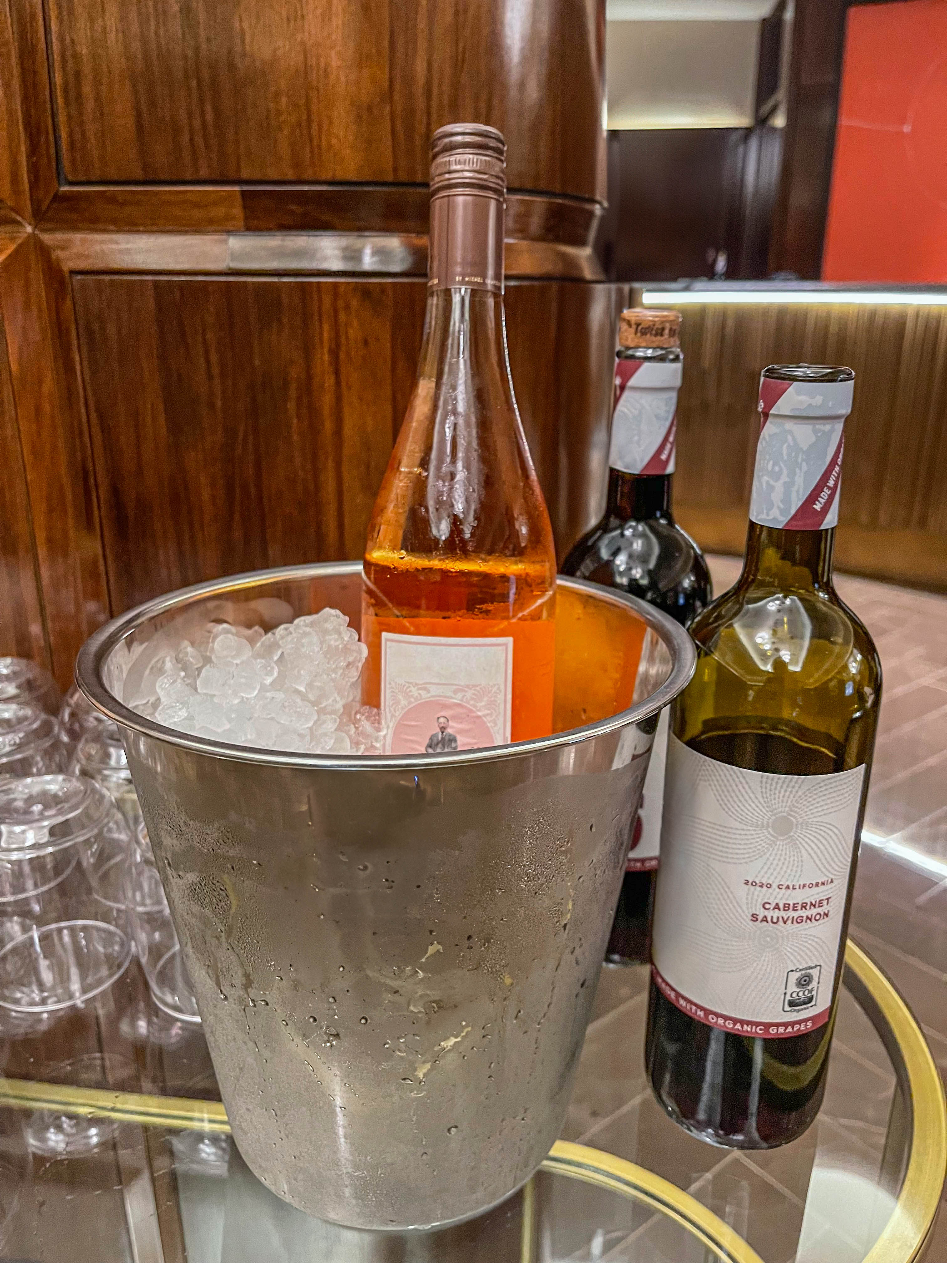 a metal ice bucket with wine bottles and glasses