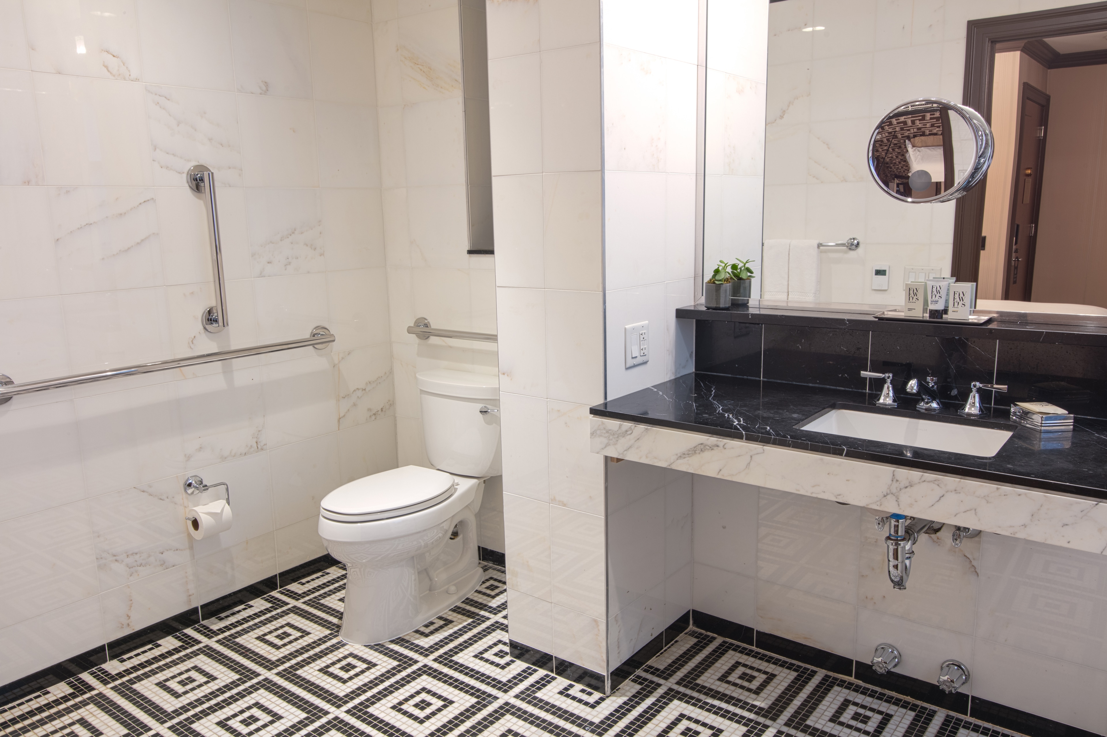 A clean bathroom with a toilet, sink, and marble tiles