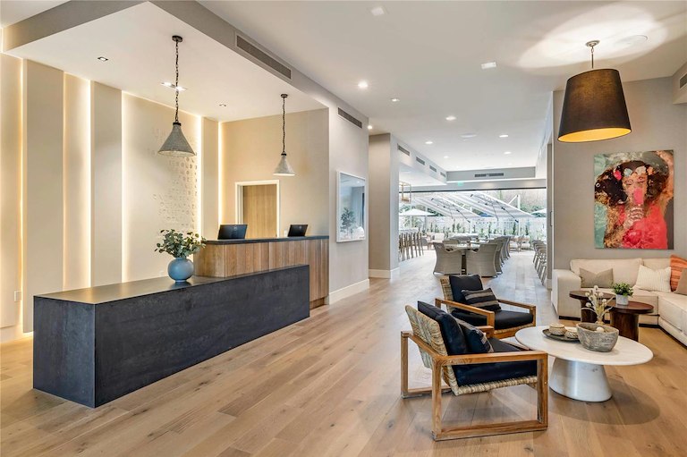 Modern apartment building lobby featuring sleek furniture and contemporary decor, with large windows allowing natural light.