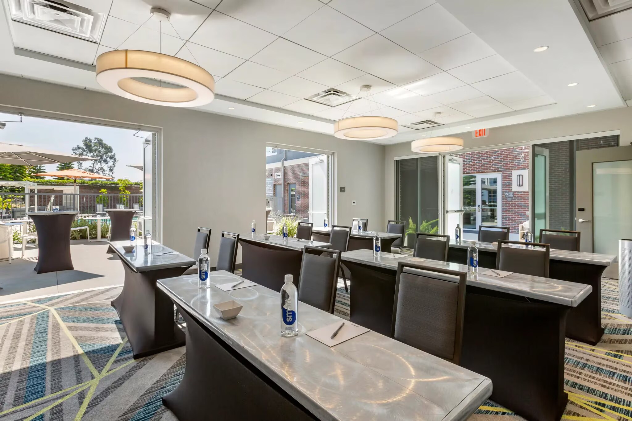 A bright conference room with modern decor, featuring three tables set