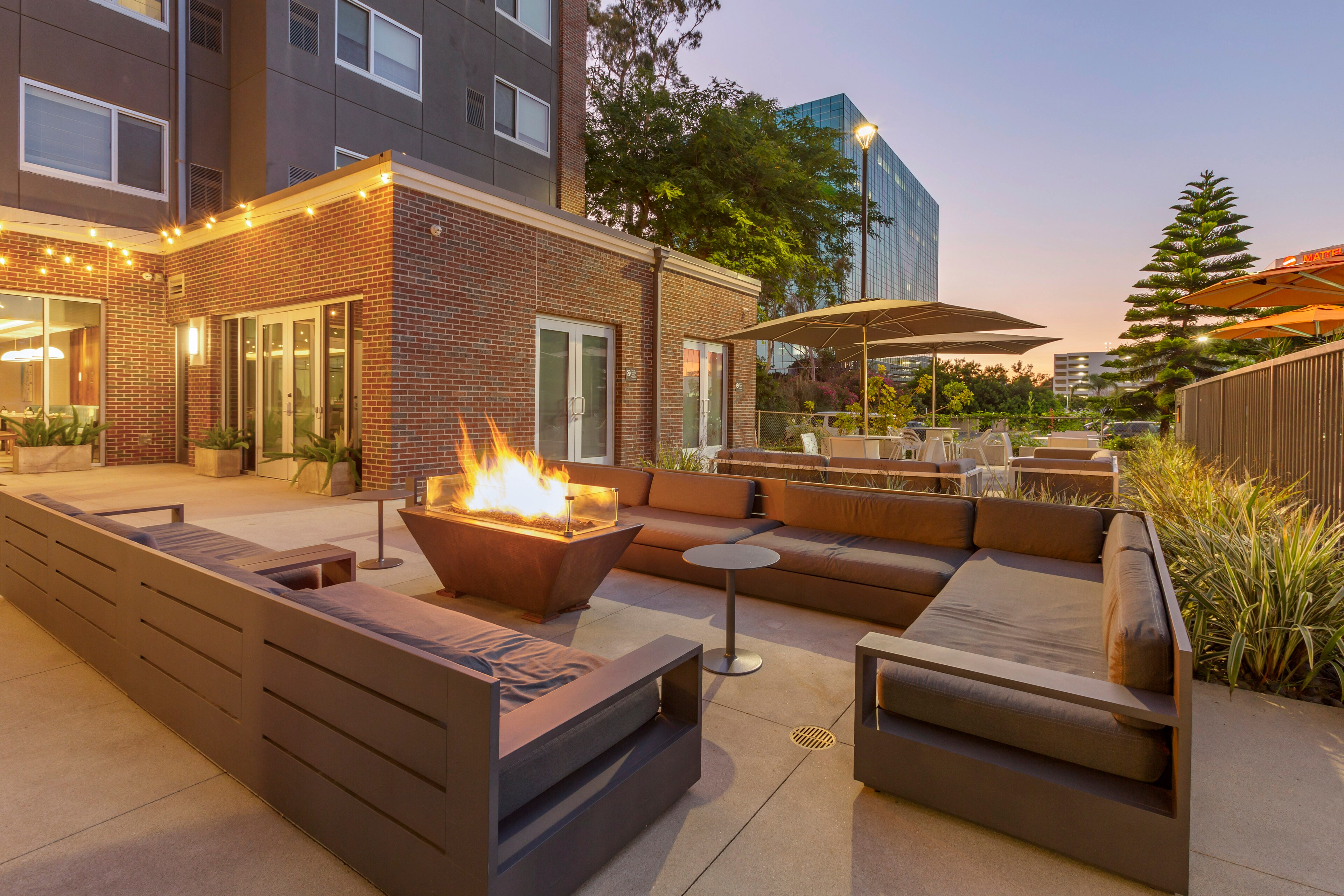Outdoor patio with modern seating around a central fire pit at sunset