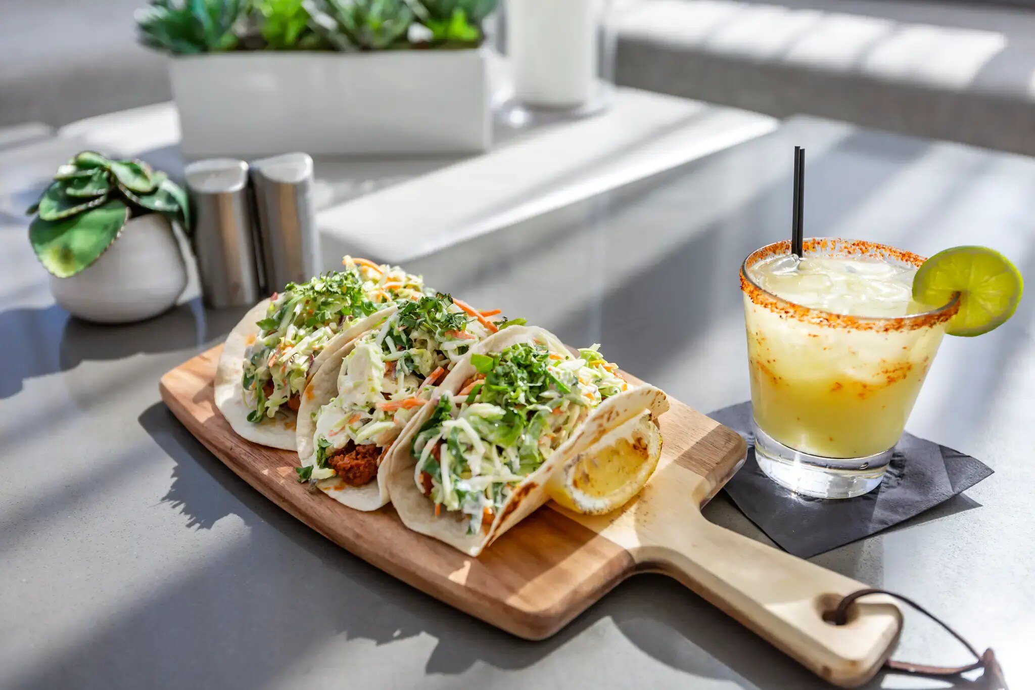 On a table, a taco and a drink are displayed, showcasing the Eat + Drink offers