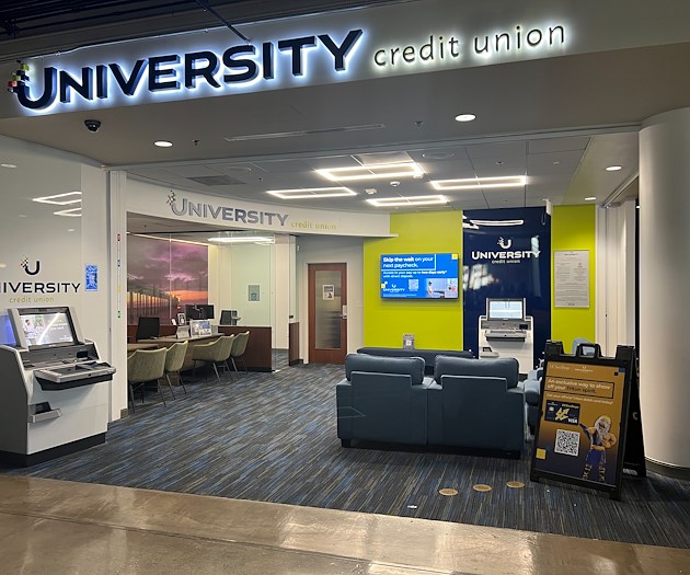 A photograph of a UCU and UC San Diego branded office that contains seating and tables