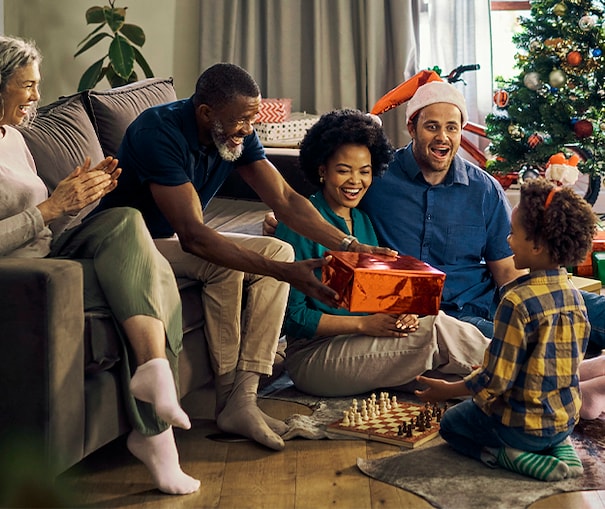 Multiple generations of family members giving holiday gifts to each other