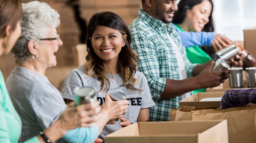 Young woman working with a group of volunteers at a university food pantry event