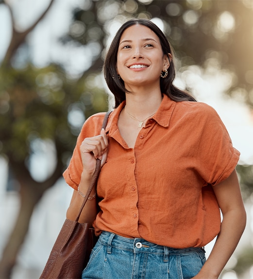 Smiling young woman confidently walking around campus.
