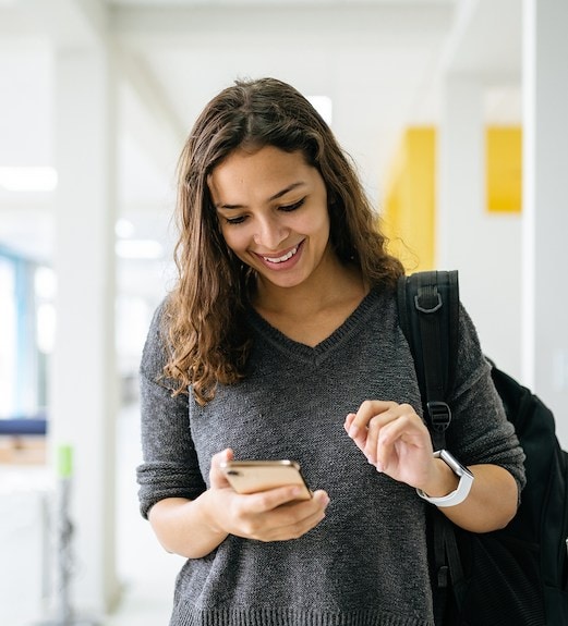 I young woman smiling and looking down at her phone