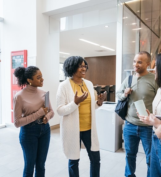 A group of adults standing in a group and speaking 