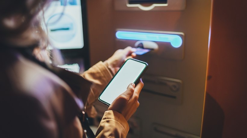 A person using a phone to pay for a card