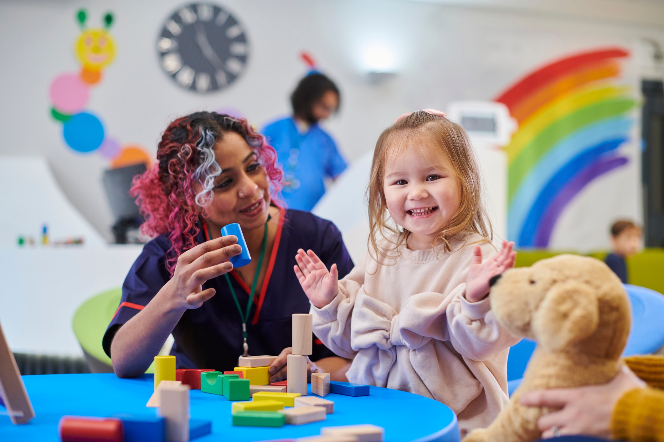 A woman and a child playing with blocks