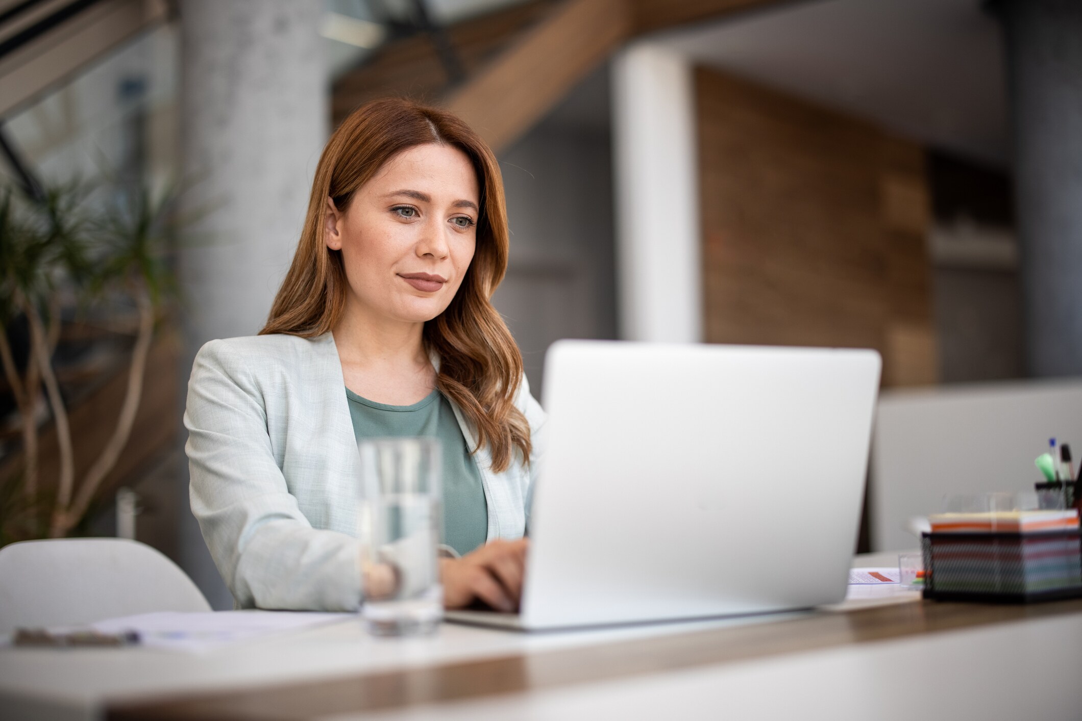 A Woman Seated At A Table Focused On Her Laptop at El Segundo California