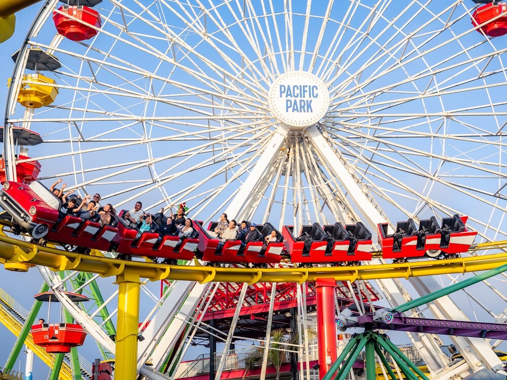 Roller coaster and ferris wheel at Pacific Park, Santa Monica, California