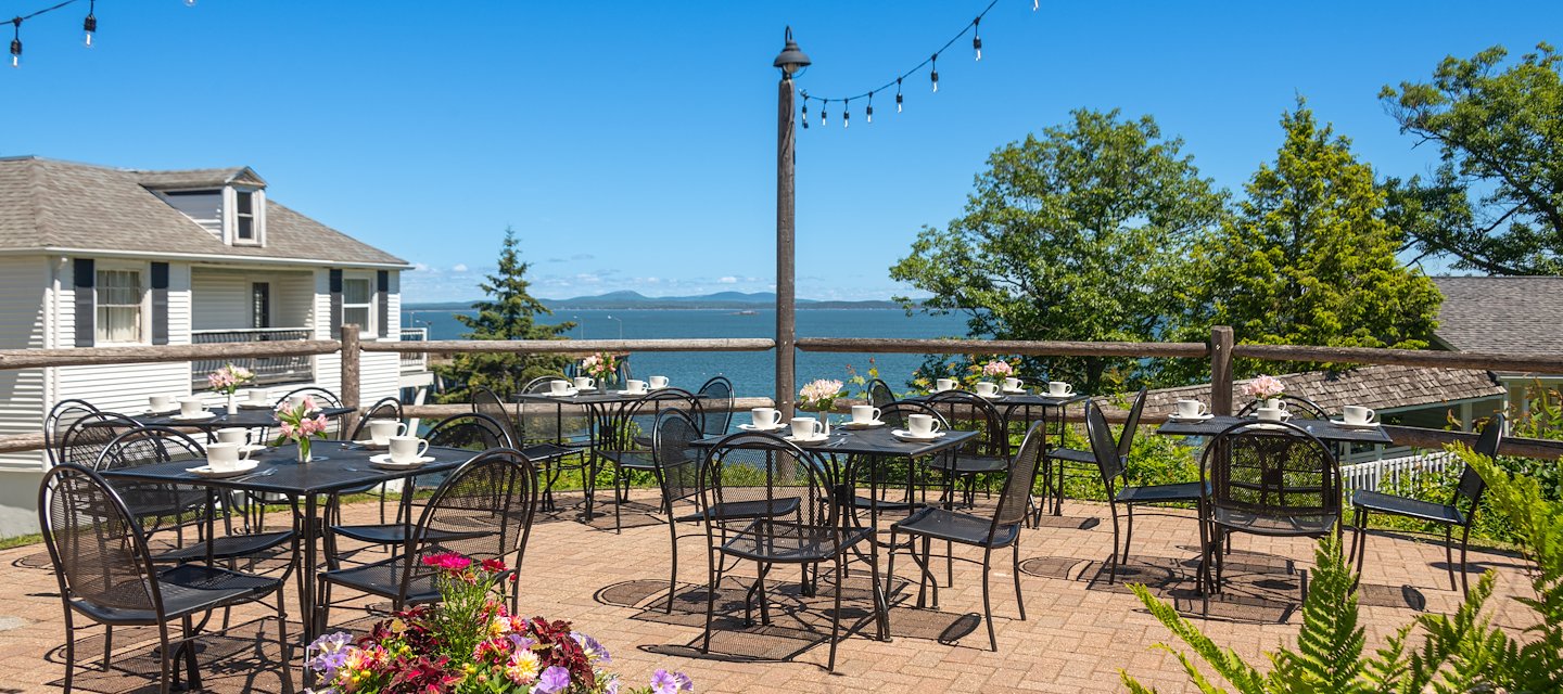 A seaside restaurant patio for two with flowers and ocean views