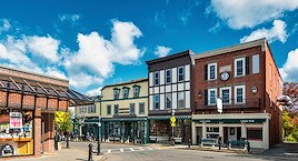 A quaint small-town street under a bright blue sky
