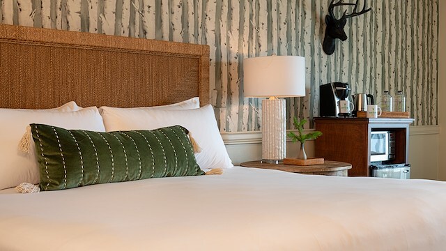 A cozy room at The Bayview Hotel, featuring lush green pillows and beautiful decor.