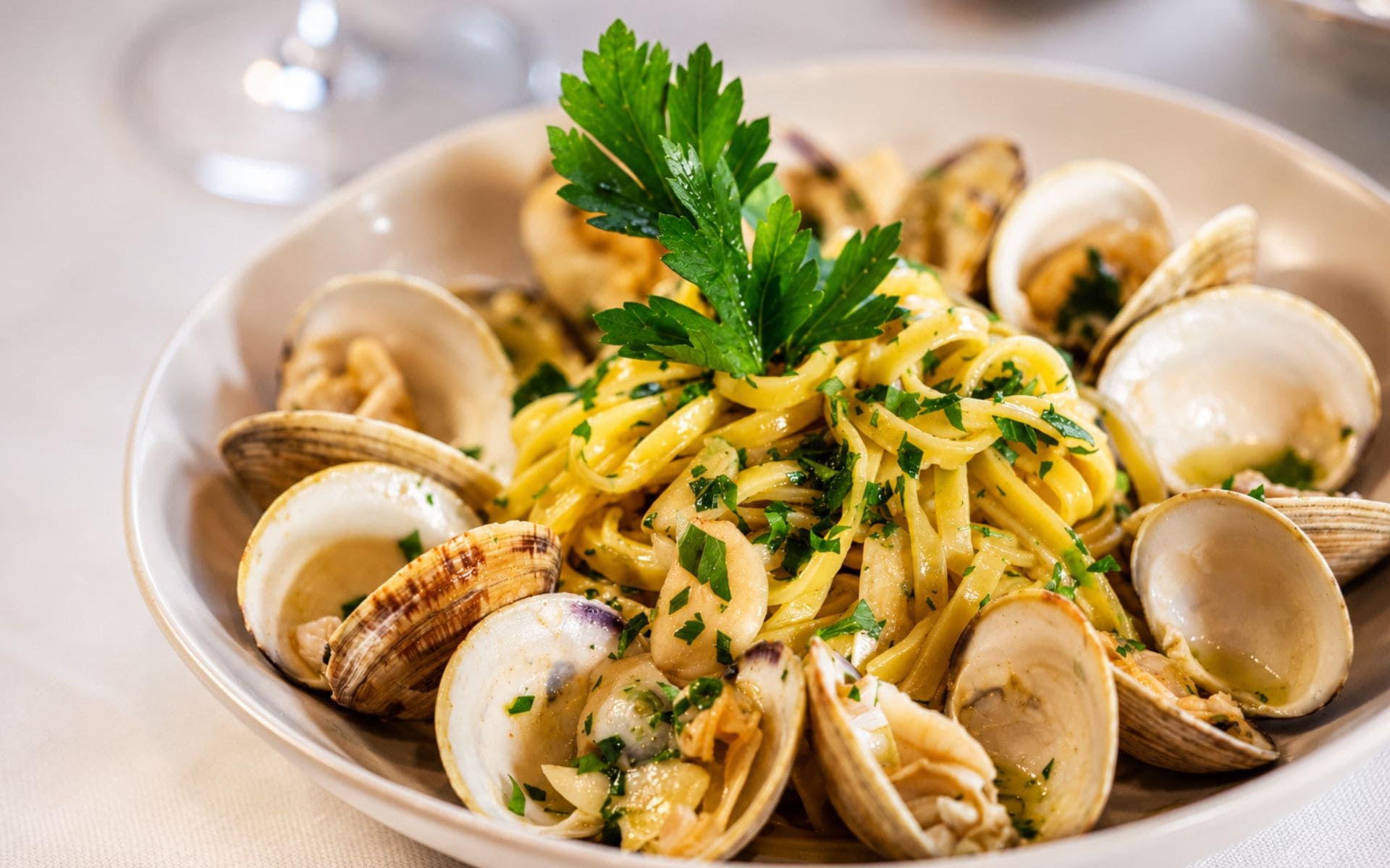 a plate of linguine with clams and parsley on top