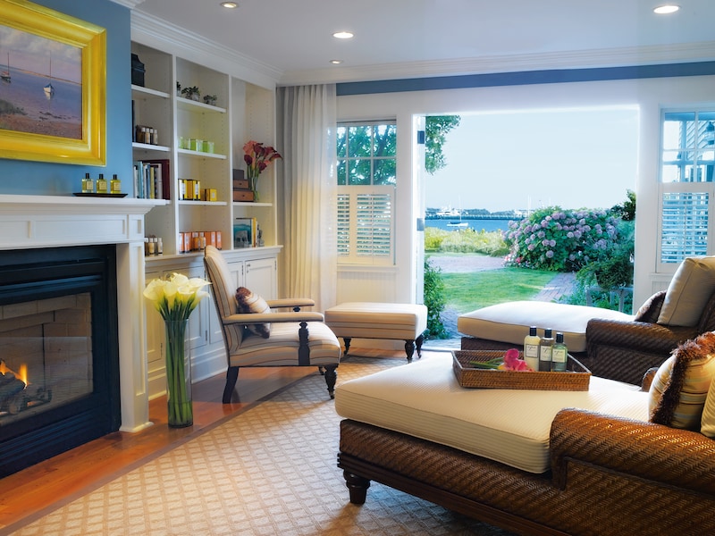 A cozy lounge area with a fireplace, comfortable seating, and a view of the outdoors.