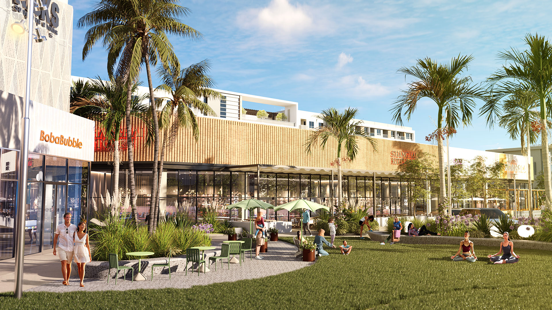 A courtyard with palm trees, outdoor seating, and buildings in the background.